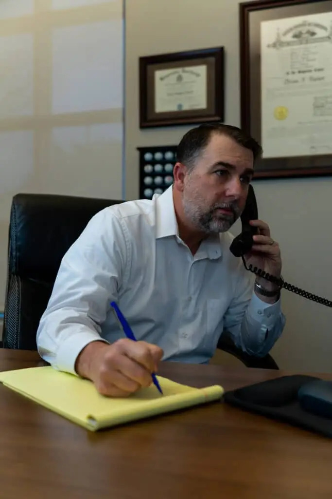 Man writing something down while talking on the phone