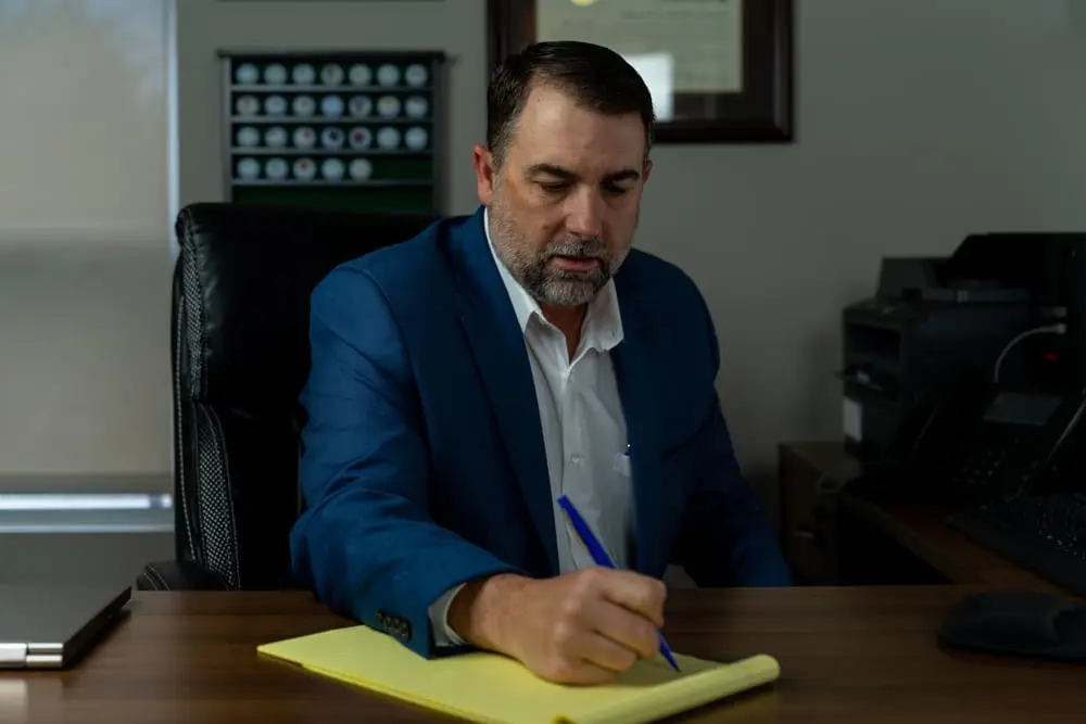 Man writing something down on a notepad