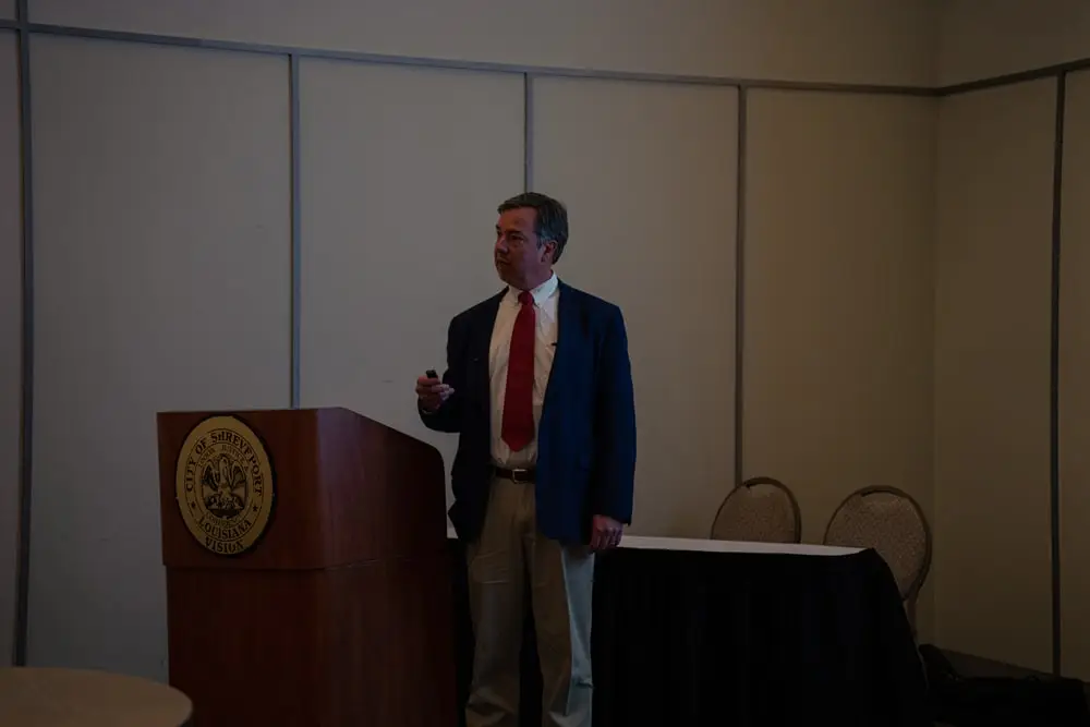 Man speaking beside a podium