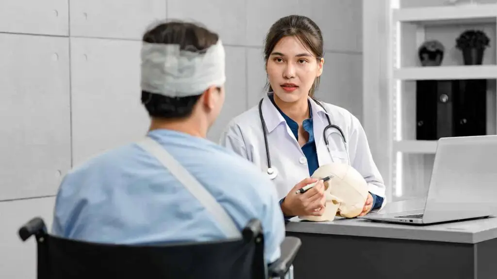 Doctor in white lab coat with stethoscope holding skull model