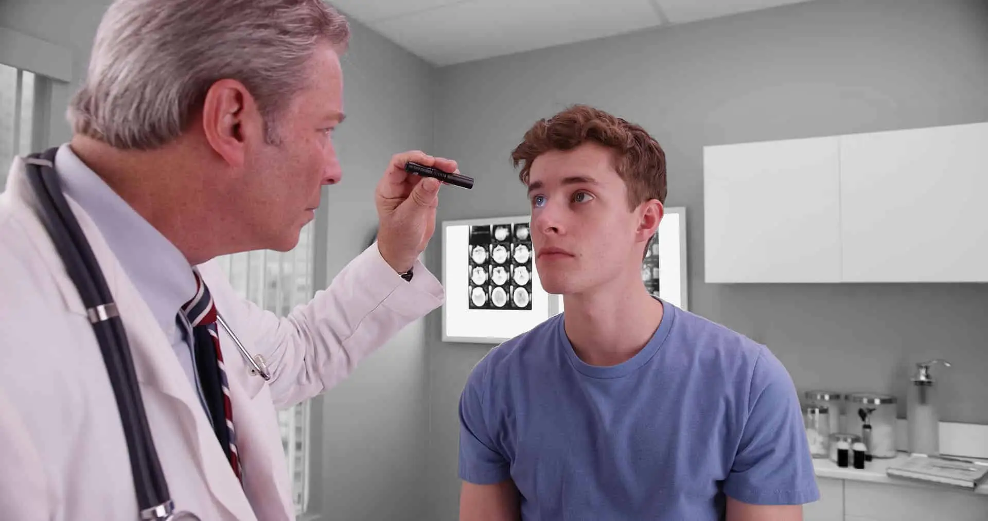 Mid-aged doctor examining eyes of young adult male patient.