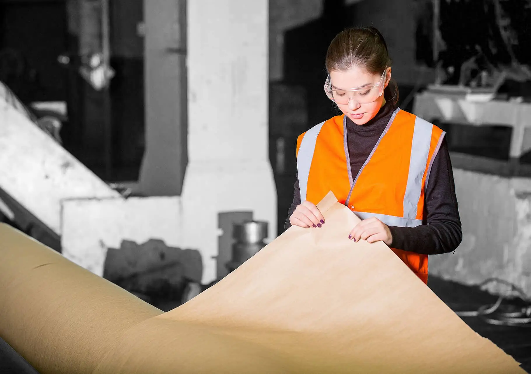 Paper mill factory worker inspecting a roll of paper