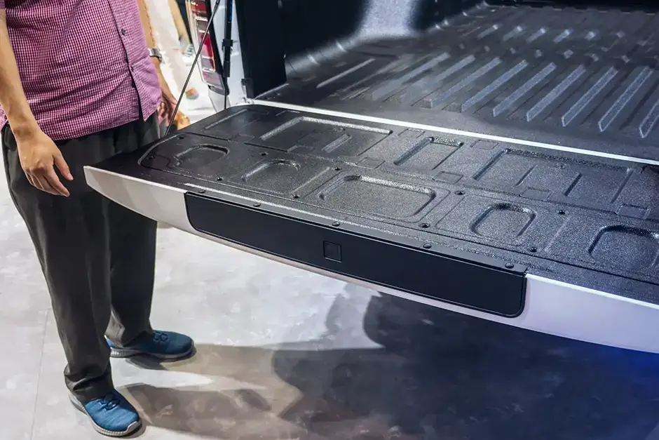 ram trucks recalled for malfunctioning tailgate. picture of a truck tailgate open by a person