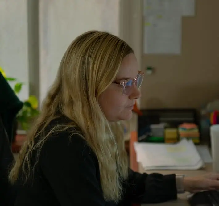 Woman with glasses looking at a computer