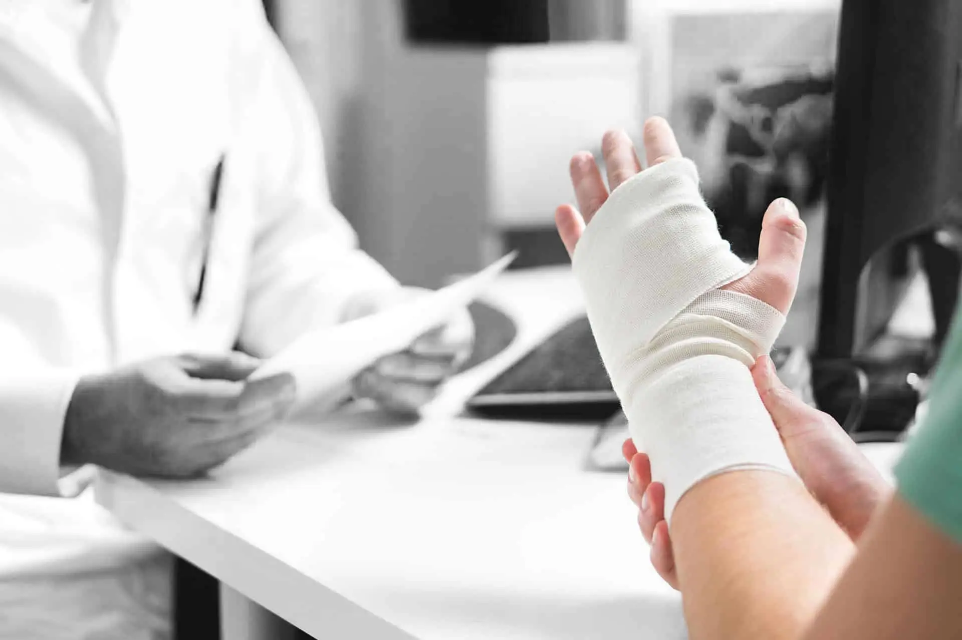 Injured patient showing doctor broken wrist and arm with bandage