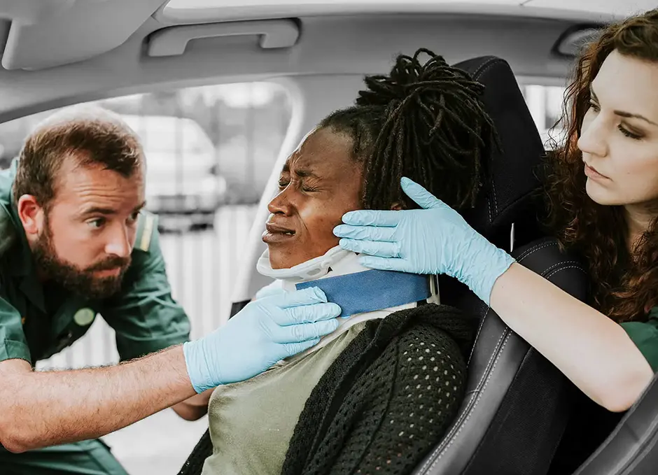 Paramedic placing a cervical collar to an injured woman from car accident