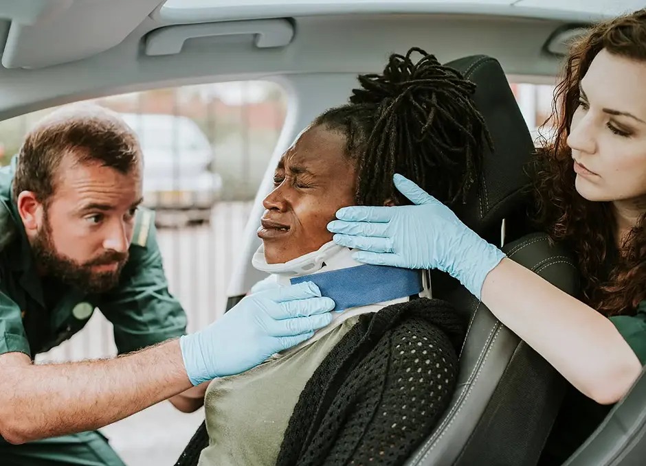 Paramedic placing a cervical collar to an injured woman from car accident
