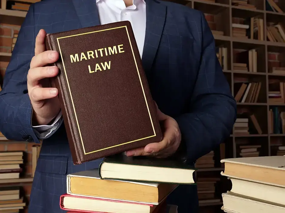 a law book being held may a man in a blue blazer with maritime law written on the cover