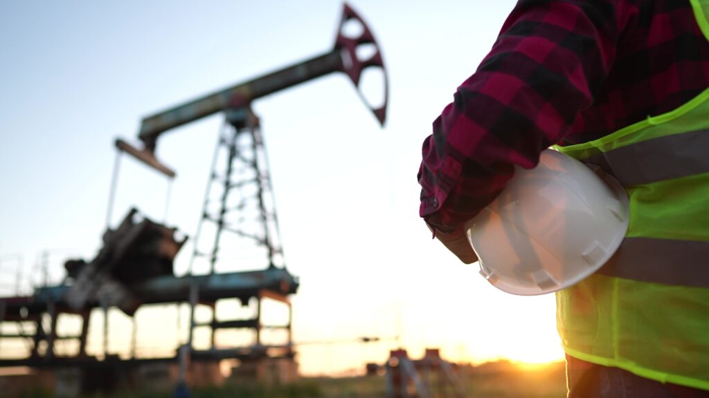 Oil,production. ,a,worker,holding,a,protective,hard,hat,at